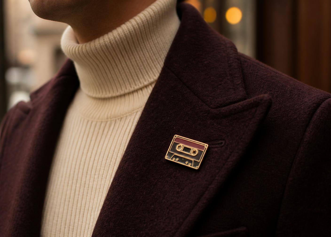 Person wearing a PinME Retro Cassette enamel pin on their lapel